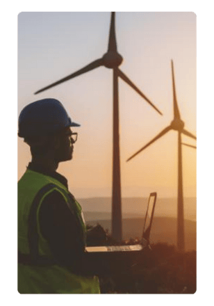 Man looking out at wind turbines